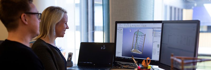 Bureau d'études Arena Jeux devant un logiciel de conception 3D